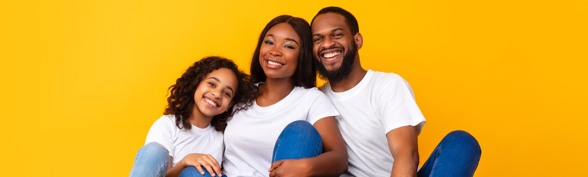 Black family sitting on the floor together smiling