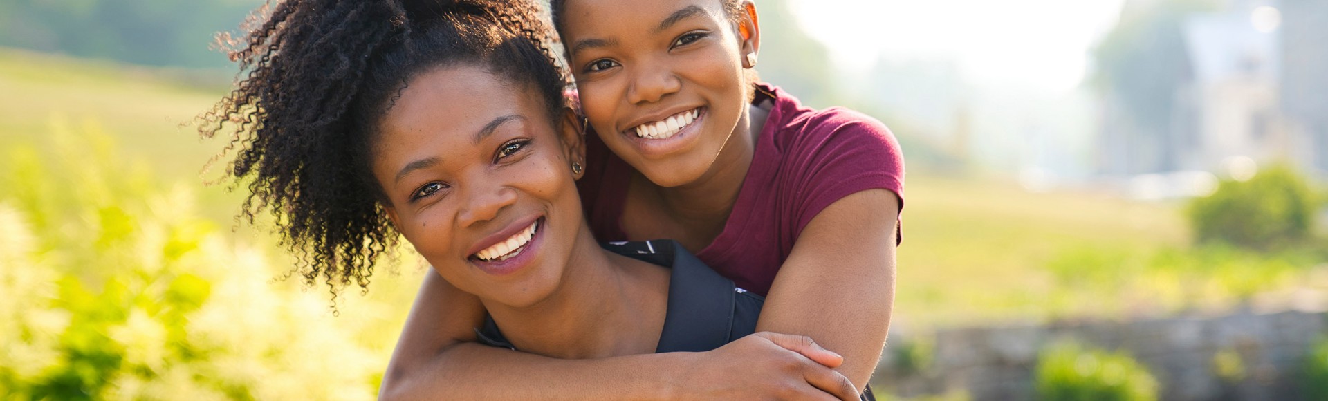 black mother and daughter smiling at the camera