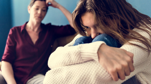 upset daughter with concerned mother in the background