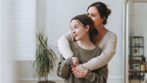 Mother hugging daughter from behind