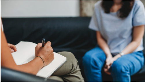 Young woman in therapy with person sitting across from them in a room