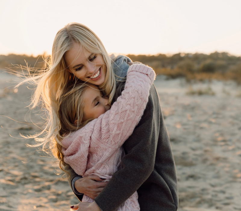 Mother and daughter hugging on a beach